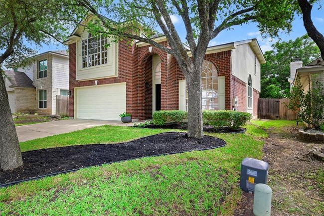 Traditional-style house featuring brick siding, a garage, and driveway | Image 6