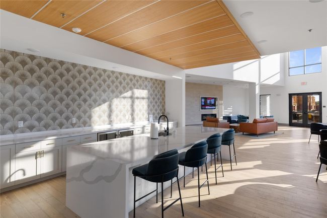 Kitchen featuring wallpapered walls, an accent wall, a kitchen island with sink, a breakfast bar, and light wood-type flooring | Image 30