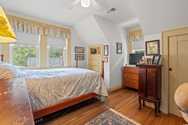 Bedroom with wood finished floors, lofted ceiling, and a ceiling fan | Image 19