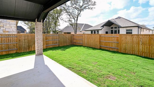 Fenced backyard with a patio | Image 22