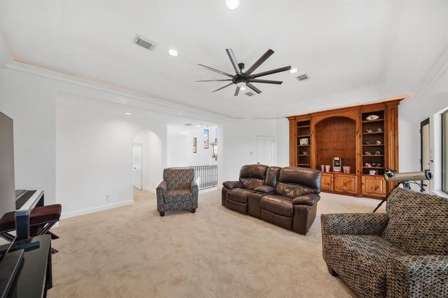 Located on the second level of the home is a game room with a recessed ceiling illuminated by cove lighting, recessed lights, a ceiling fan with light fixture & storage closet. All of the carpet on the second floor of the home is new as of March 2025. | Image 26