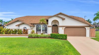 View of front of property featuring a front yard and a garage | Image 1