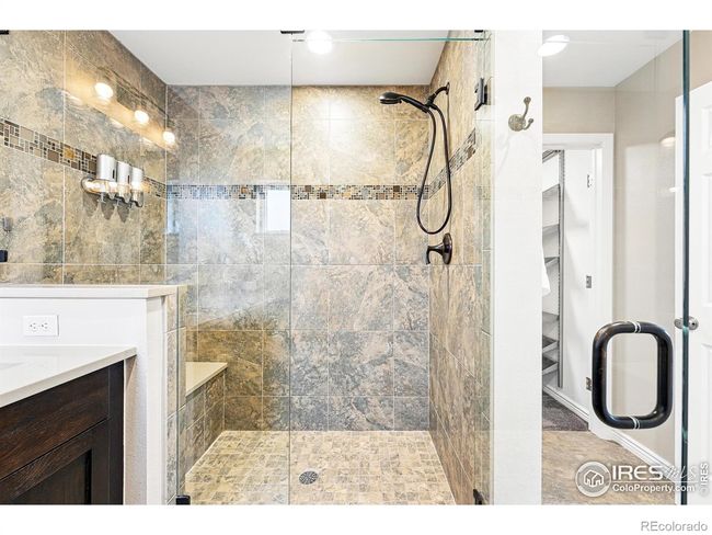 custom tile and shower with a bench for the ensuite primary bath | Image 19