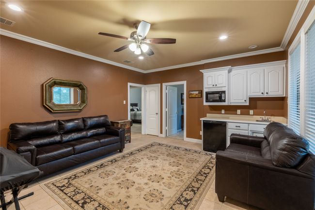 Family room featuring sink, microwave, cabinets, mini fridge, ceiling fan, tile flooring, recessed lighting, ornamental molding | Image 19