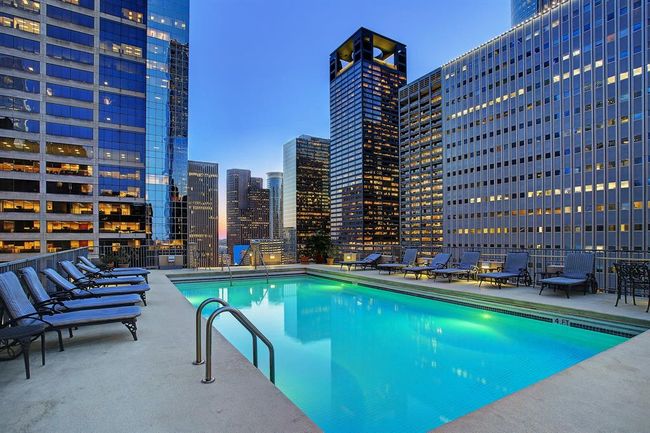 A dusk view of Commerce Towers heated rooftop pool! Imagine relaxing by the pool in the evenings with the twinkling lights of the surrounding buildings! | Image 28