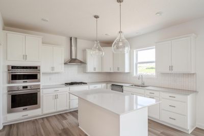 (Photo of an inventory home, actual homes finishes will vary) This impressive gourmet kitchen features the highly desirable wall oven's, gas cook top & vented hood, large island for easy entertaining, walk-in pantry, & more. | Image 2