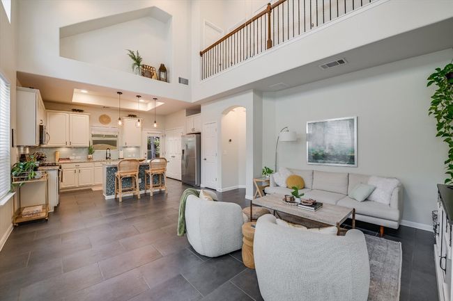 Living room featuring arched walkways, a high ceiling, and baseboards | Image 13