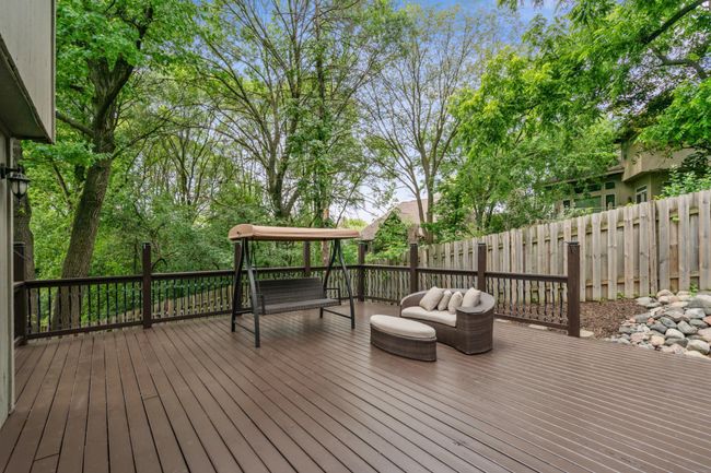 Spacious deck surrounded by privacy fencing and mature trees—ideal for outdoor lounging and entertaining. | Image 31