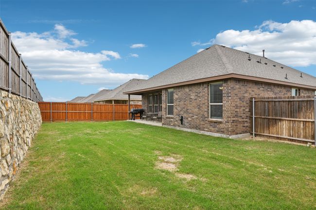 Rear view of house with brick siding, a patio area, and a shingled roof | Image 37