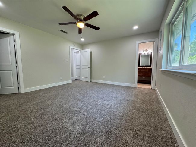 Unfurnished bedroom featuring baseboards, recessed lighting, carpet flooring, ensuite bath, and visible vents | Image 17