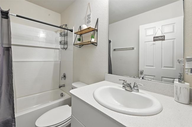 Full bath featuring vanity, shower / tub combo, and a textured wall | Image 15
