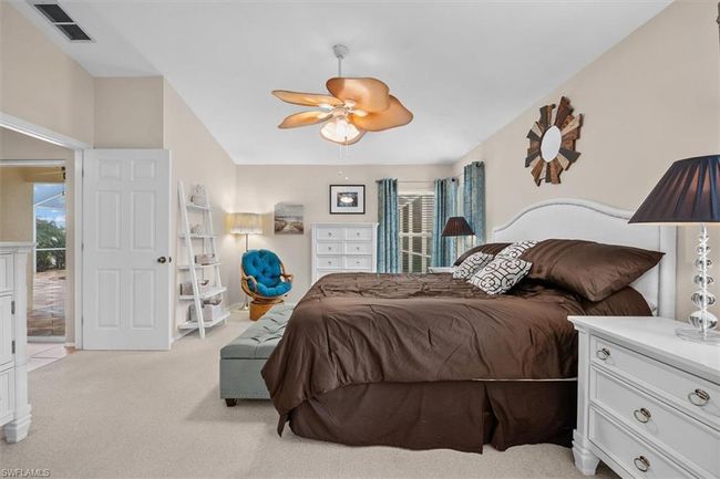 Bedroom featuring visible vents, light carpet, a ceiling fan, and multiple windows | Image 22