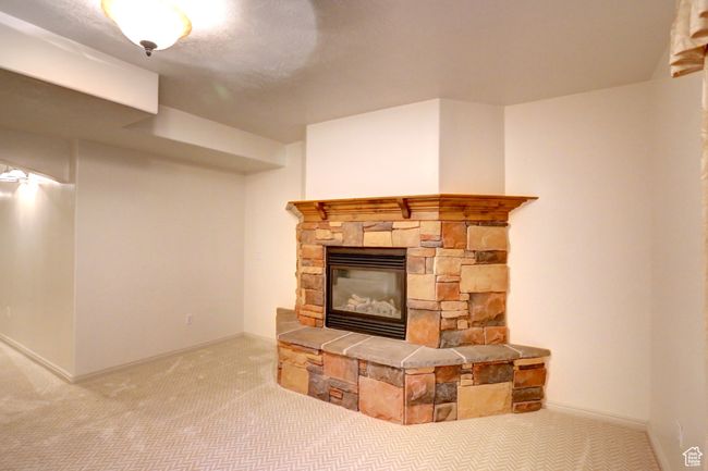 Unfurnished living room featuring carpet floors, baseboards, and a fireplace | Image 40