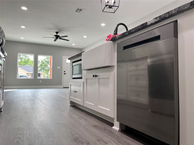 Kitchen featuring wood finished floors, recessed lighting, ceiling fan, white cabinetry, and open floor plan | Image 6