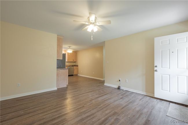 Unfurnished living room with baseboards, ceiling fan, and dark wood finished floors | Image 7