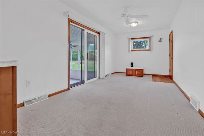 Empty room with ceiling fan, light colored carpet, and baseboards | Image 14
