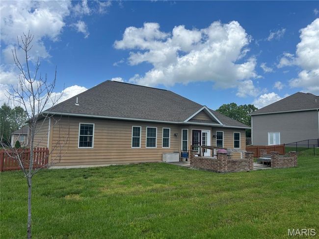 Rear view of house featuring a patio area, a fenced backyard, a shingled roof, and an outdoor living space | Image 21