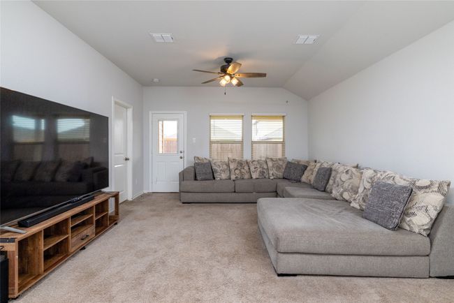 Living area with ceiling fan, light carpet, and lofted ceiling | Image 16