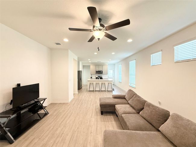 Living area featuring light wood-style flooring, a ceiling fan, recessed lighting, and baseboards | Image 6