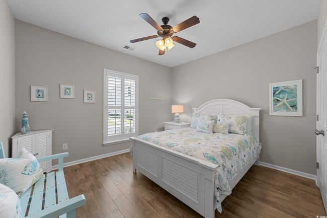 Bedroom with baseboards, dark wood-style flooring, and ceiling fan | Image 25