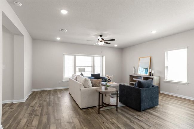 Living room featuring baseboards, visible vents, wood finished floors, and a ceiling fan | Image 5