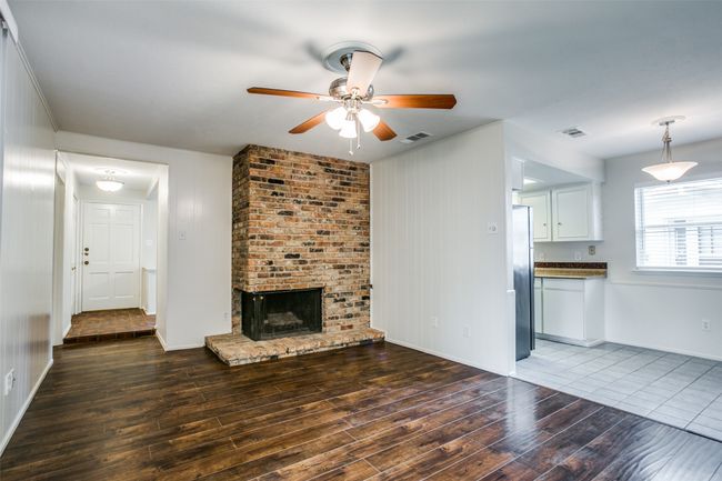 Unfurnished living room with wood finished floors, a ceiling fan, and a fireplace | Image 7