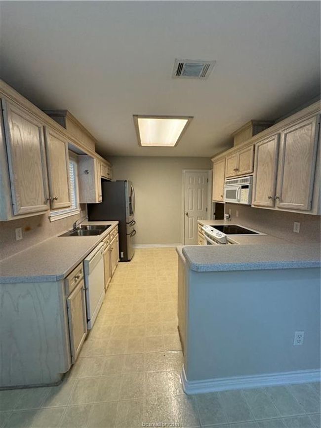 Kitchen featuring white appliances and a peninsula | Image 6