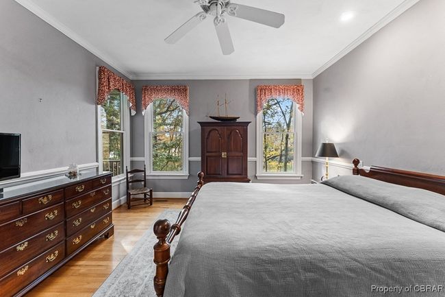 Bedroom with light wood-style flooring, multiple windows, crown molding, and a ceiling fan | Image 27