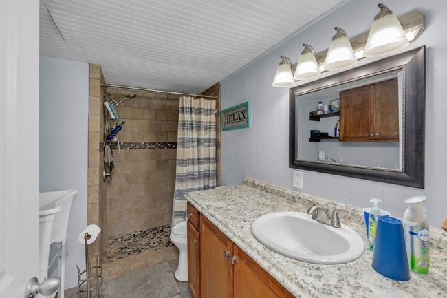 Bathroom with vanity and tiled shower | Image 25
