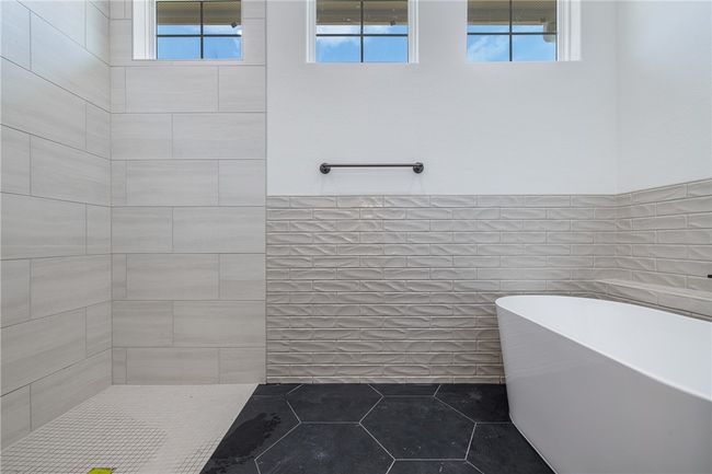 Bathroom featuring a tub, a healthy amount of sunlight, and tile walls | Image 18