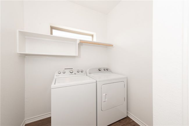 Clothes washing area with dark wood finished floors, washing machine and dryer, baseboards, and laundry area | Image 14