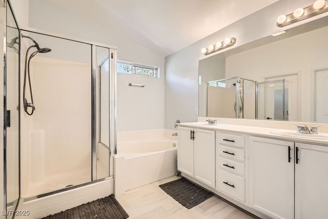 Bathroom with vaulted ceiling, a shower stall, a sink, a garden tub, and double vanity | Image 16
