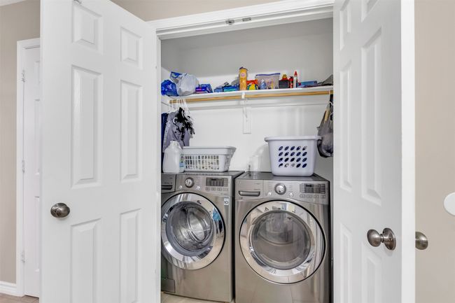 Laundry area featuring washing machine and clothes dryer and tile patterned floors | Image 12