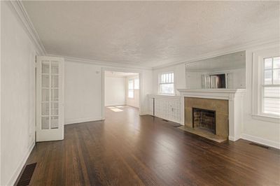 Unfurnished living room with a textured ceiling, a fireplace, dark hardwood / wood-style floors, and crown molding | Image 3