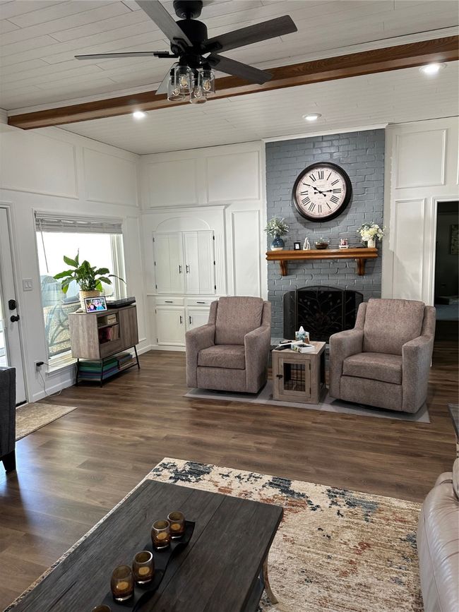 Living room featuring beamed ceiling, a fireplace, a ceiling fan, and dark wood-type flooring | Image 15