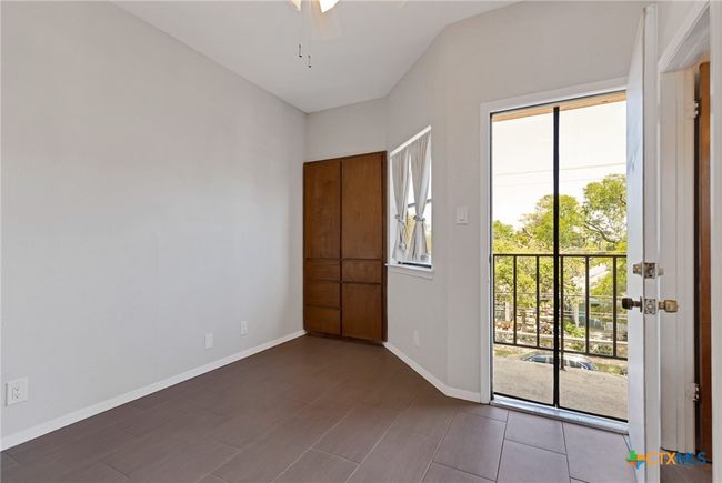 Bedroom with door to balcony and built in storage. | Image 14
