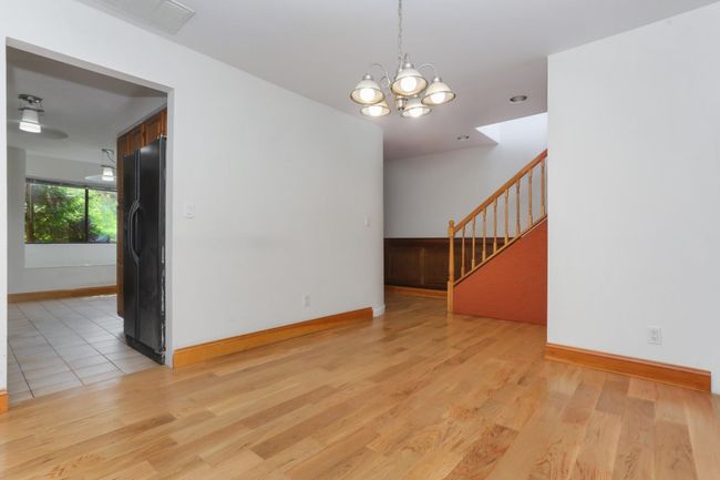 Spare room with stairway, a chandelier, light wood-style flooring, and baseboards | Image 12