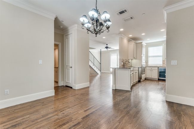Kitchen with beverage cooler, a chandelier, crown molding, recessed lighting, and dark wood-type flooring | Image 5