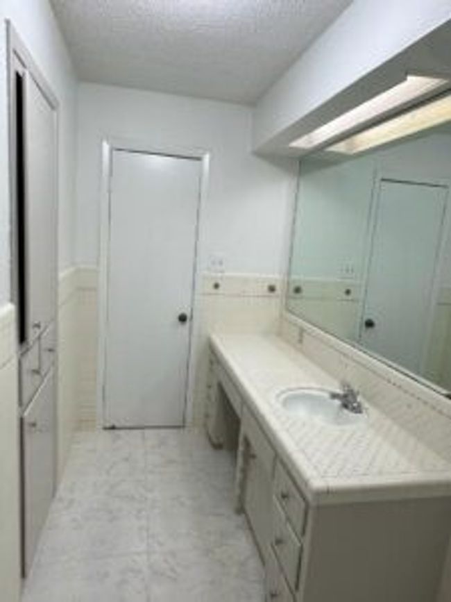 Bathroom featuring vanity, a textured ceiling, and marble finish floors | Image 22