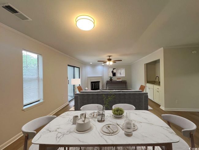 Dining area with a ceiling fan, a fireplace, visible vents, and dark wood-type flooring | Image 30