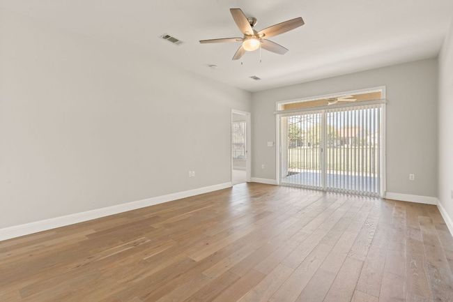 Unfurnished room featuring a ceiling fan, baseboards, light wood finished floors, and visible vents | Image 15