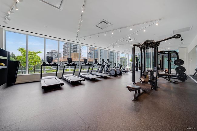 Exercise room featuring rail lighting and a view of city | Image 15