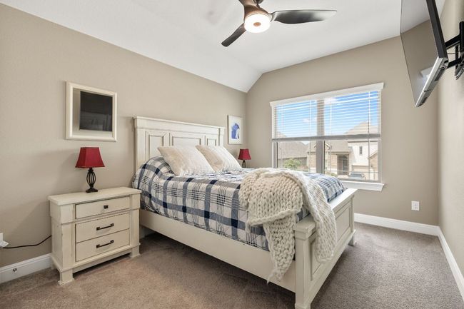 Bedroom 2 upstairs featuring light carpet, lofted ceiling, baseboards, and ceiling fan, also has a walk in closet | Image 33