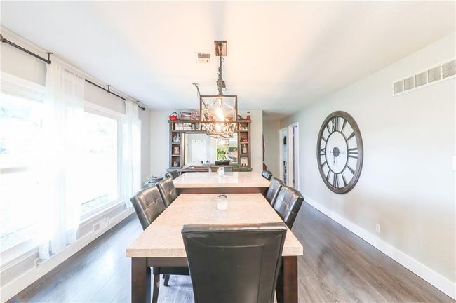 Dining area featuring dark wood-style flooring and a chandelier | Image 22