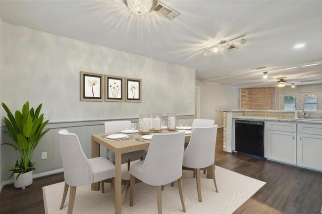 Spacious kitchen with natural light, featuring a dining area and a breakfast bar with granite countertops. The open layout connects to the living room. [virtually staged] | Image 4