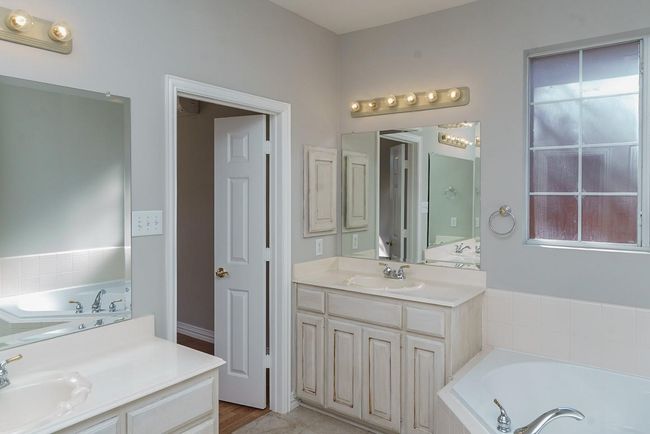 Full bathroom featuring two vanities, a sink, and a bath | Image 12