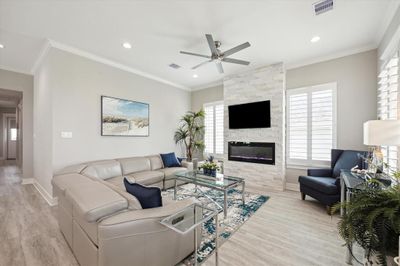 Spacious living area with plantation shutters and electric fireplace. | Image 2