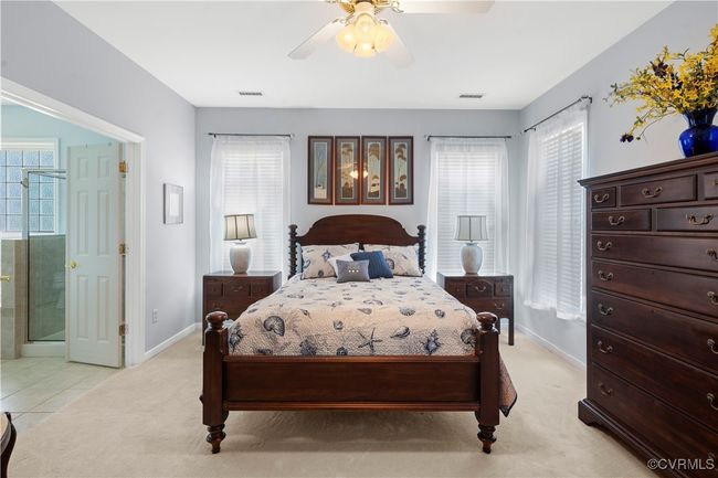 Bedroom featuring light carpet, ensuite bathroom, and ceiling fan | Image 26