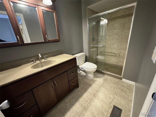 Bathroom featuring walk in shower, vanity, toilet, and tile patterned floors | Image 23