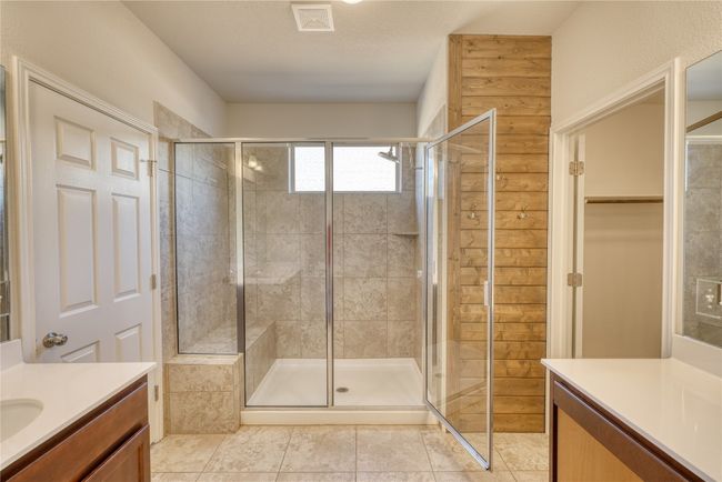 Full bathroom featuring tile patterned floors, visible vents, a shower stall, a spacious closet, and vanity | Image 21
